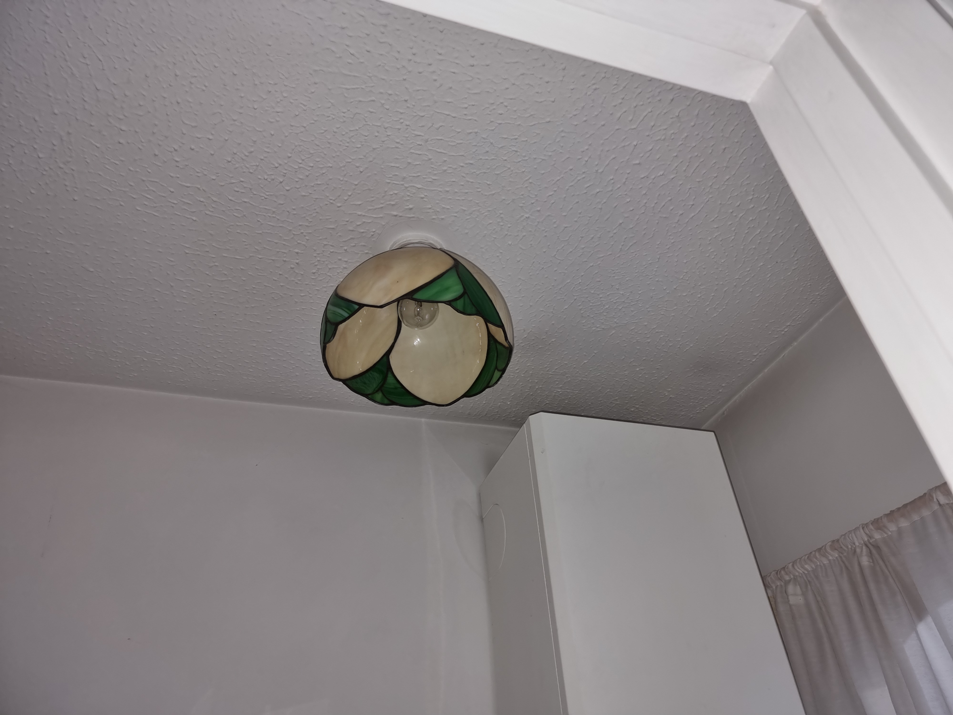 Ceiling with stippled textured coating and central light fitting in a domestic room.