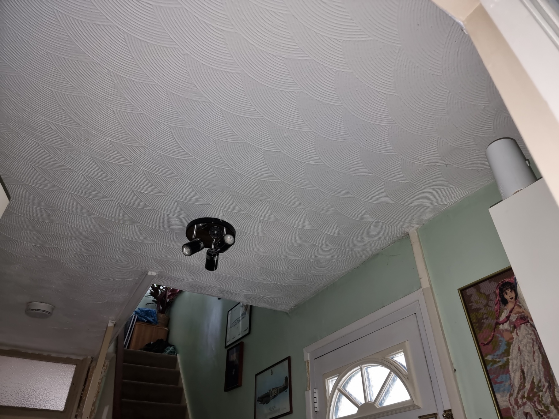 Decorative artex ceiling with repeating fan pattern above a hallway and staircase.
